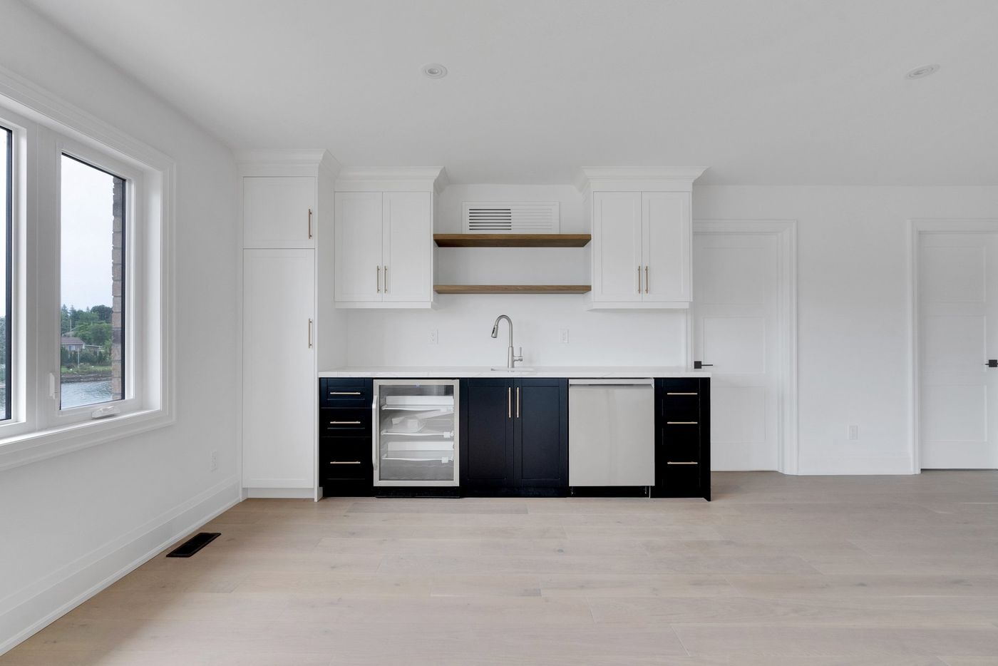 Wet bar with black cabinetry and open oak shelves